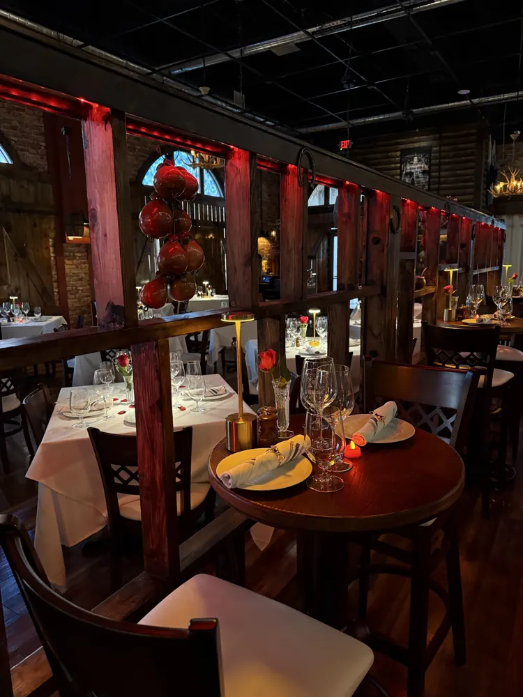 The dining room set for dinner with red accents