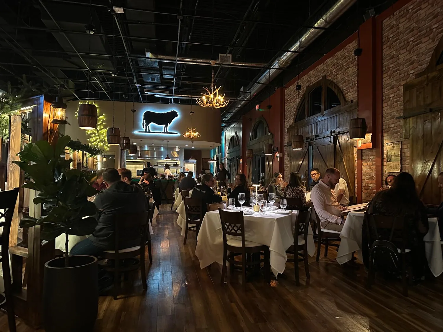 The dining room with white tablecloths and the cow emblem on the wall